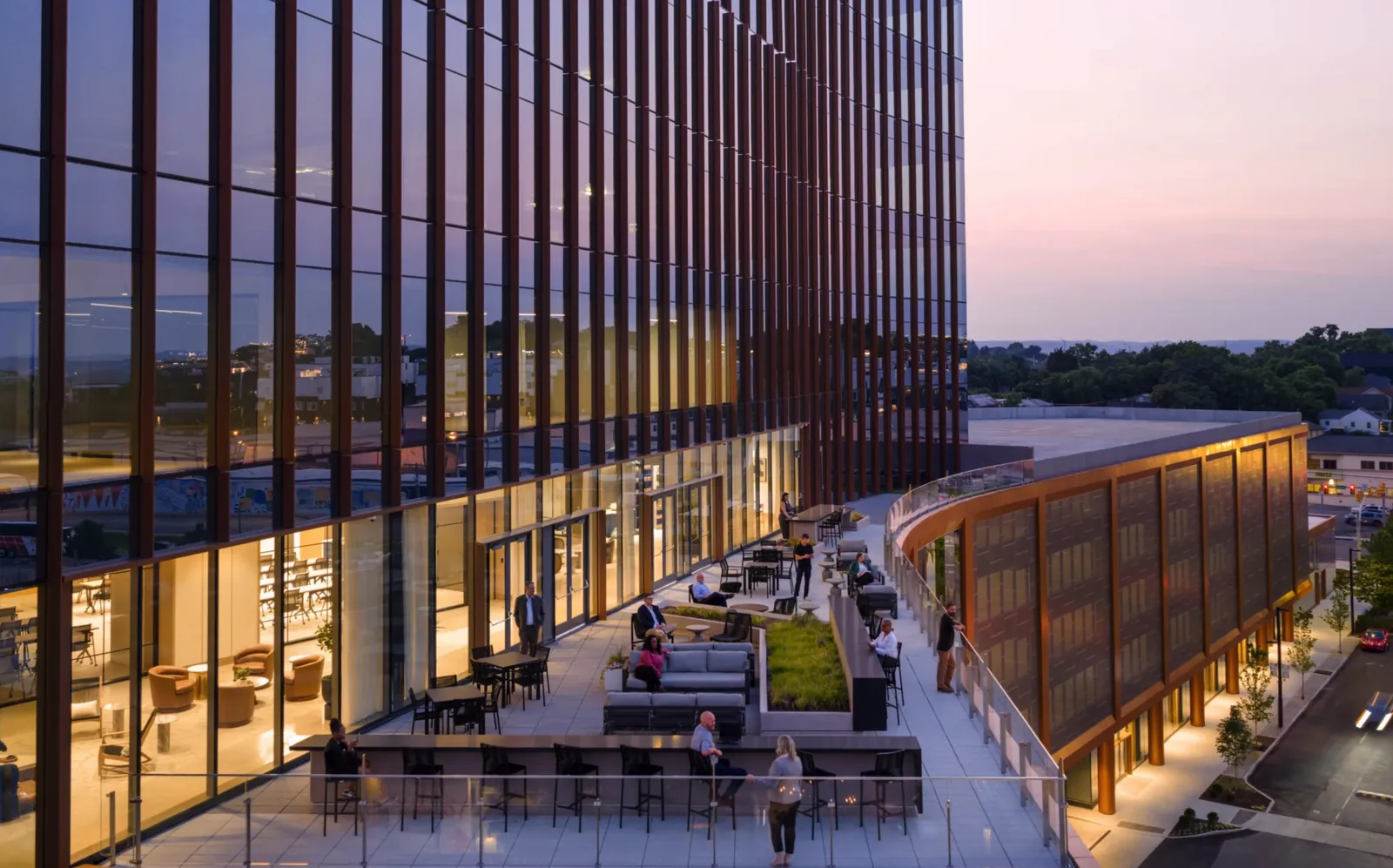 Building exterior at dusk with terrace seating